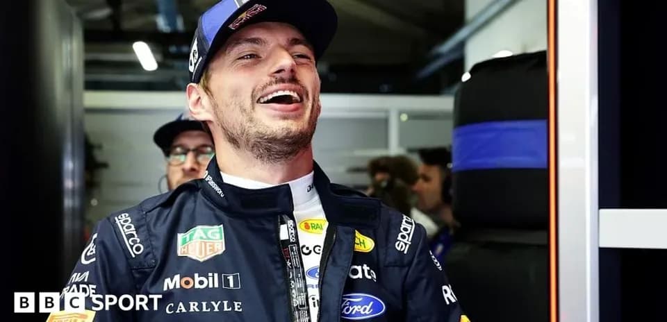 Piloto sonriendo en el garaje de su equipo