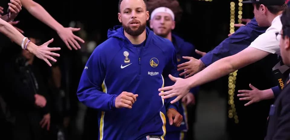 Stephen Curry corriendo hacia la cancha durante el calentamiento