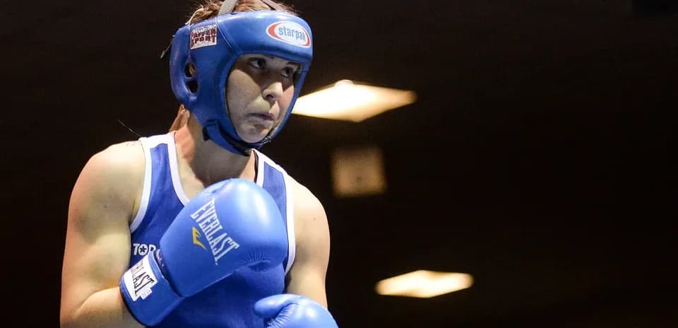 Boxeadora con guantes azules preparándose para pelear