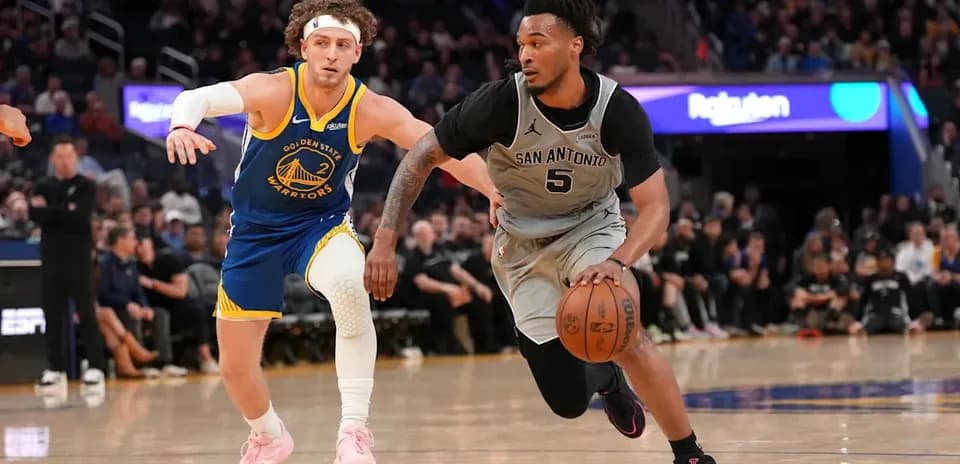 Jugador de San Antonio driblando mientras es defendido