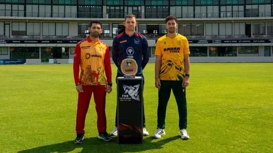 Jugadores posando con trofeo en campo de cricket