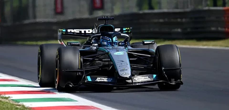 Coche de Fórmula 1 en la pista con banderas
