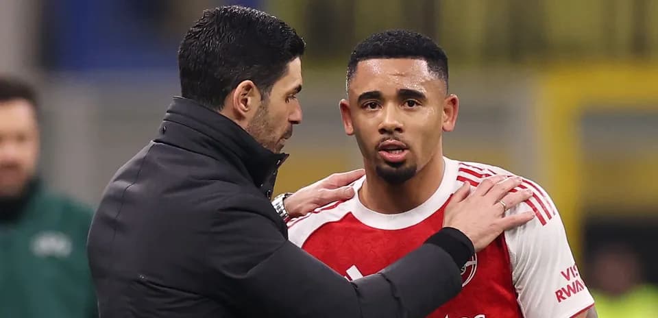 Entrenador hablando con jugador en el banquillo