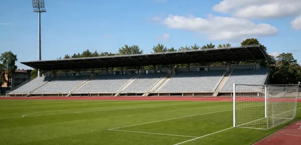 Estadio vacío con césped y gradas al fondo