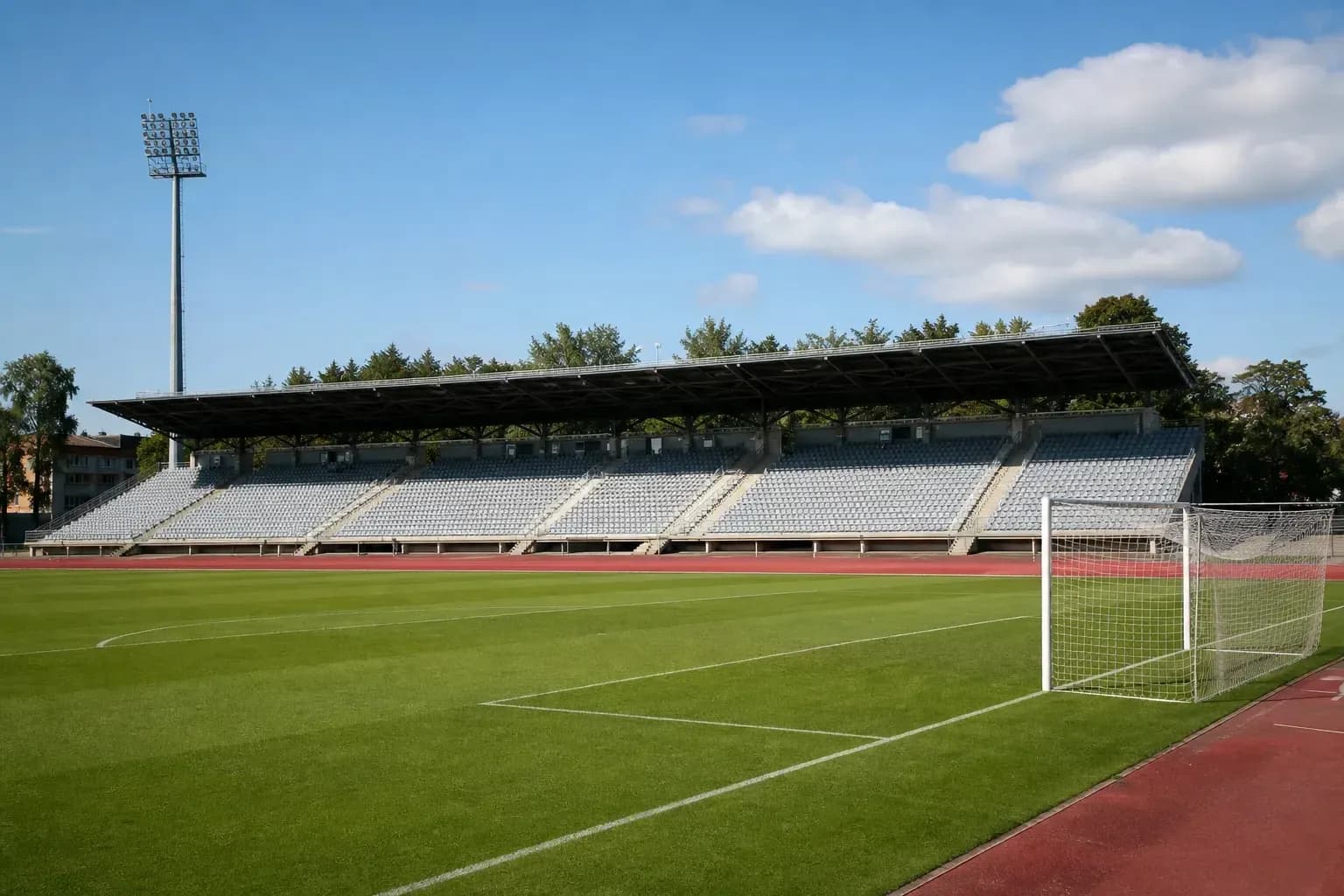 Estadio vacío con césped y gradas al fondo