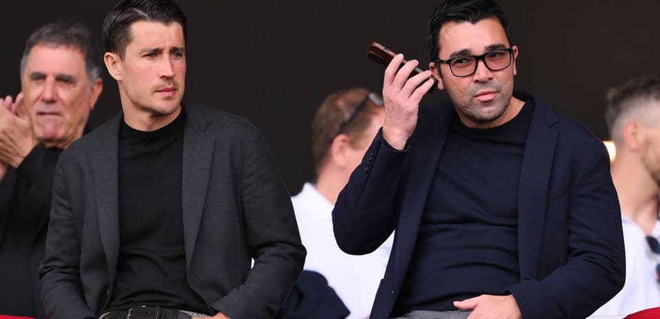 Dos hombres observando un evento deportivo desde las gradas