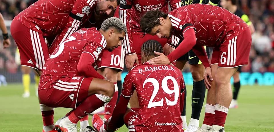 Jugadores de Liverpool consolando a compañero caído