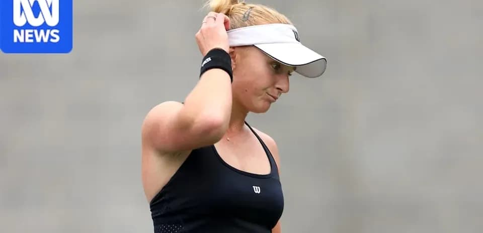 Jugadora de tenis ajustando su cabello durante el partido