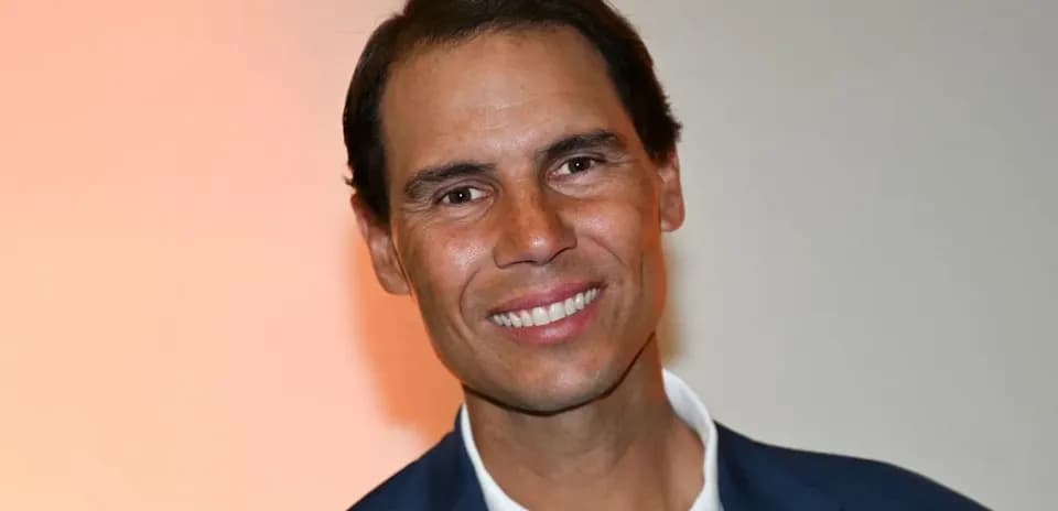 Hombre sonriendo en evento con fondo naranja