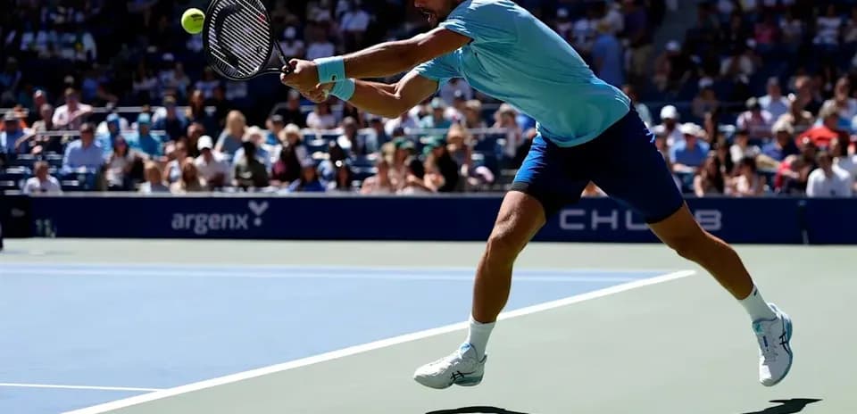 Jugador de tenis golpeando la pelota en la cancha
