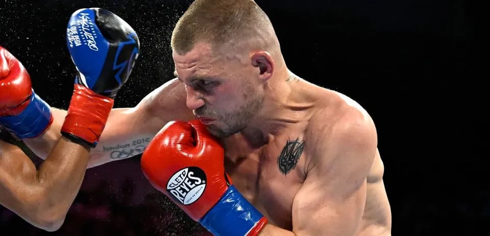 Boxeador golpeando a su oponente en el ring