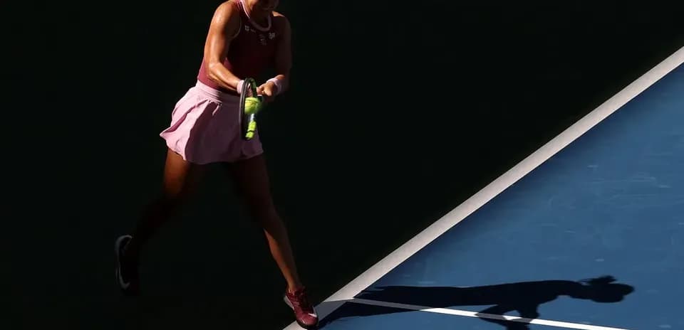 Jugadora de tenis golpeando la pelota en la cancha