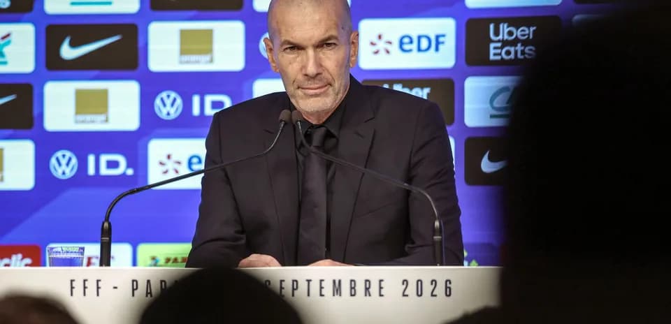 Entrenador en rueda de prensa con logotipos de patrocinadores