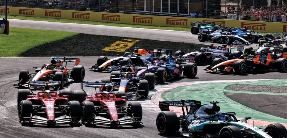 Varios coches de F1 compitiendo en curva durante carrera