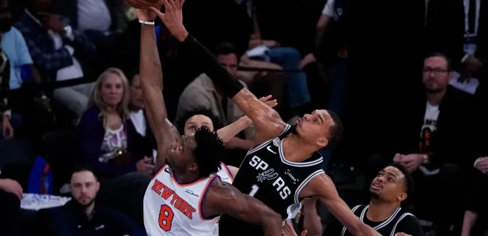 Jugador de Knicks intenta encestar contra defensores de Spurs