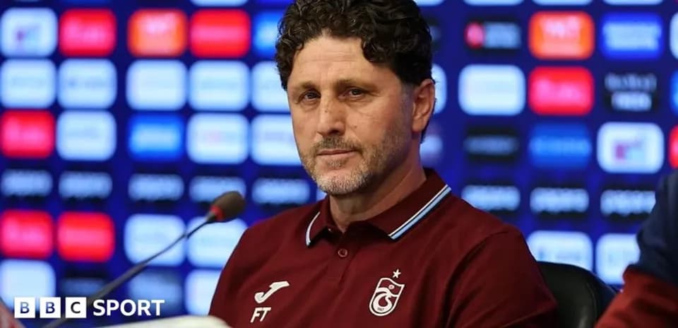 Entrenador en rueda de prensa con fondo gráfico