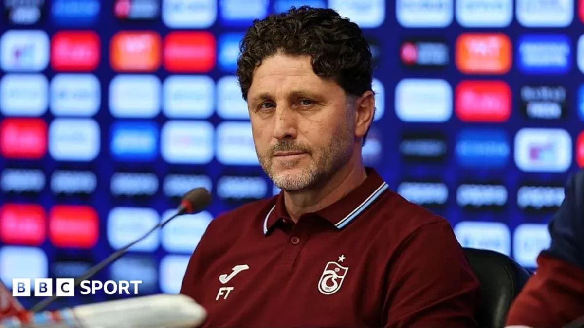 Entrenador en rueda de prensa con fondo gráfico