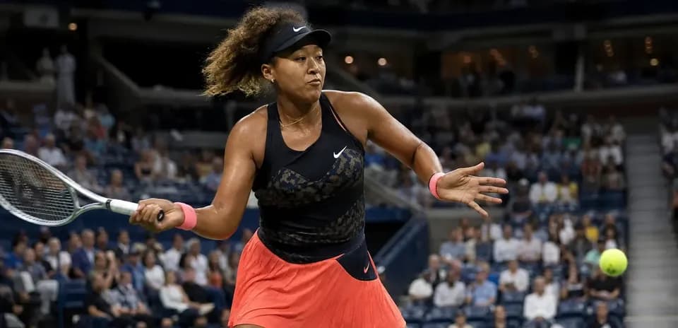 Naomi Osaka golpeando la pelota en un partido de tenis