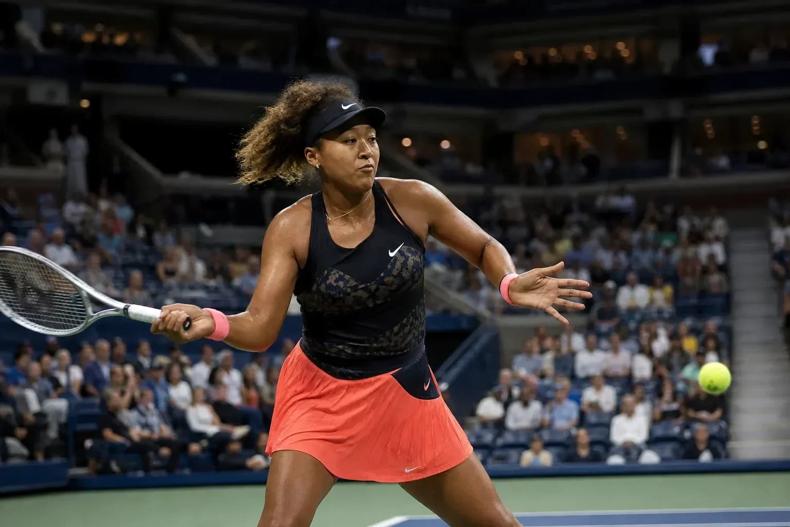 Naomi Osaka golpeando la pelota en un partido de tenis