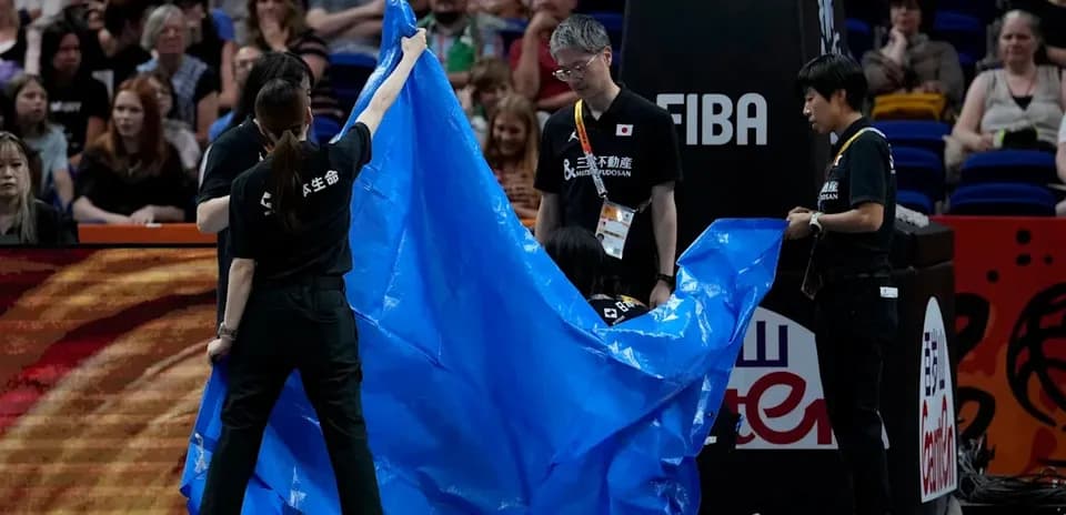 Personal de mantenimiento colocando lona azul en cancha