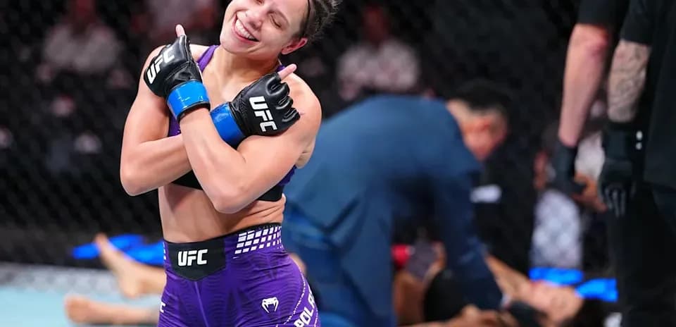 Luchadora celebrando victoria en el octágono de UFC