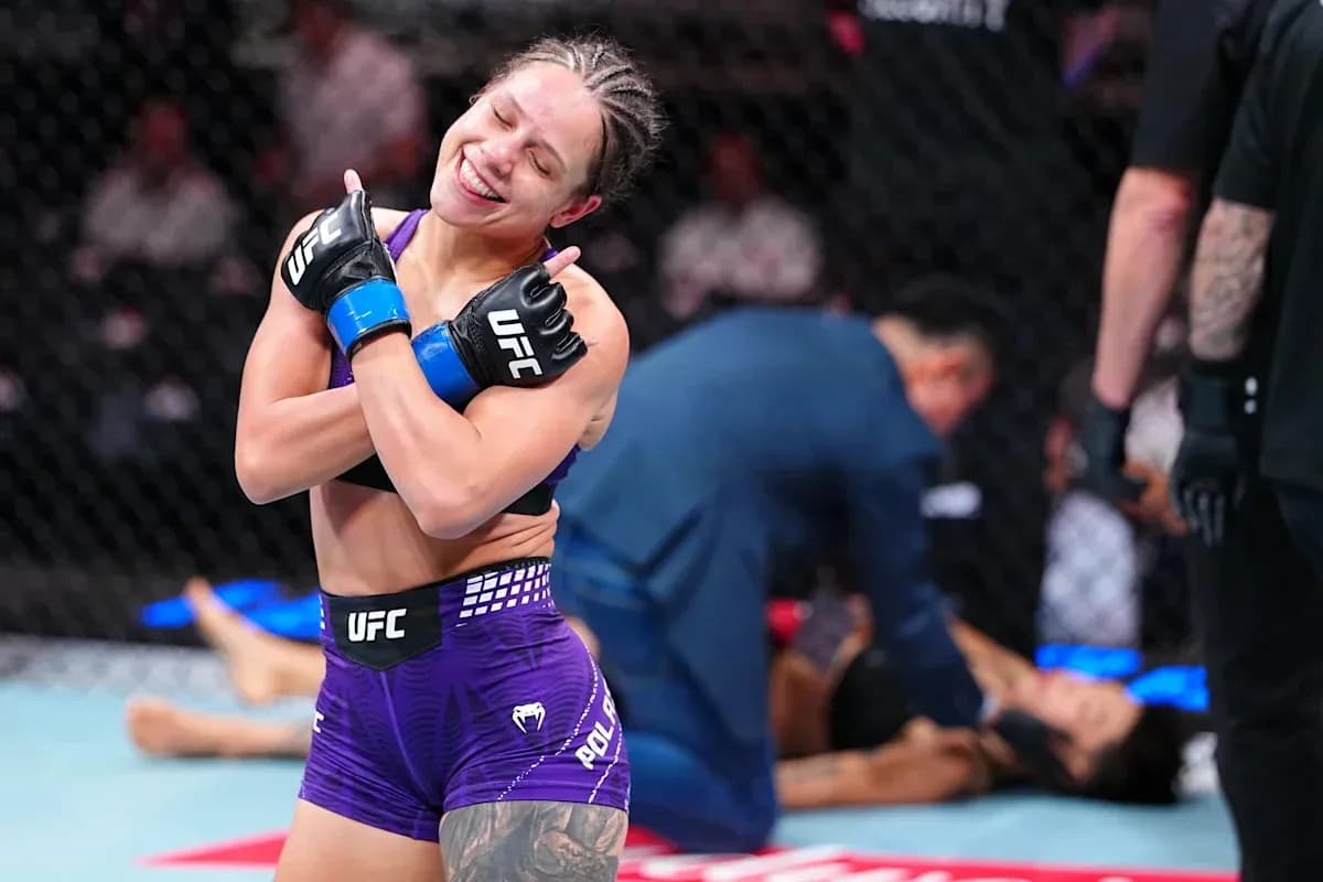 Luchadora celebrando victoria en el octágono de UFC