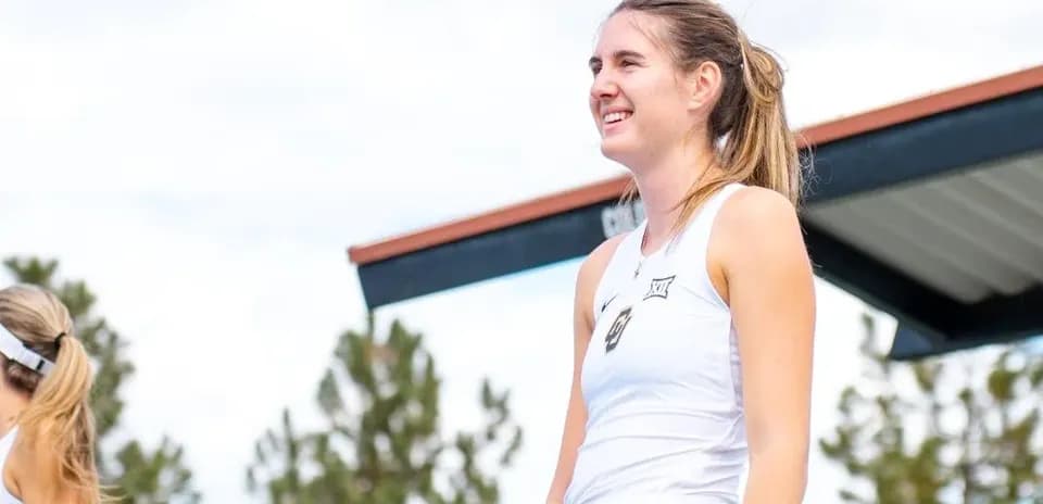 Jugadora de tenis sonriendo en la cancha al aire libre