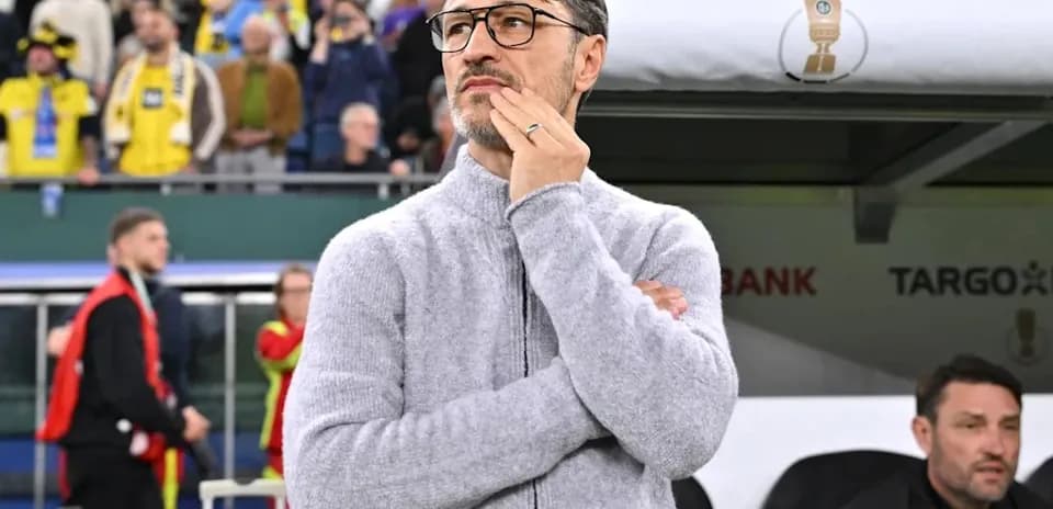 Entrenador pensativo en el banquillo durante el partido