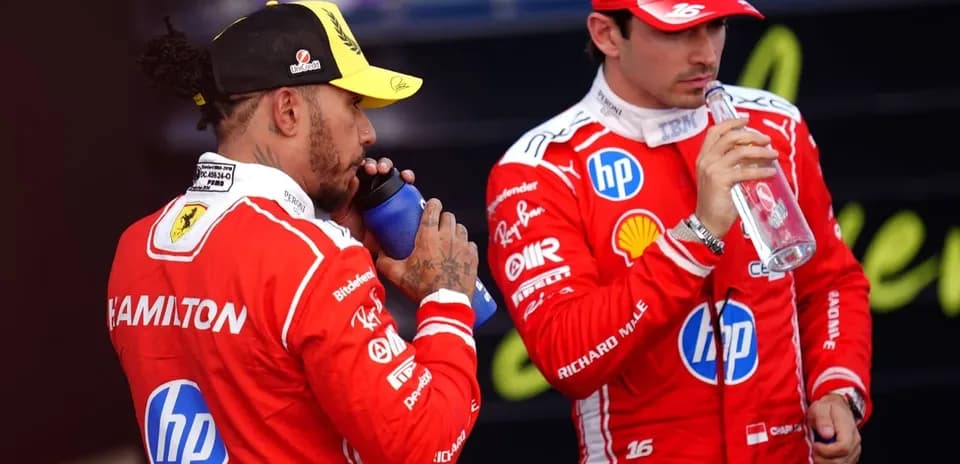 Dos pilotos de Fórmula 1 bebiendo agua en el podio