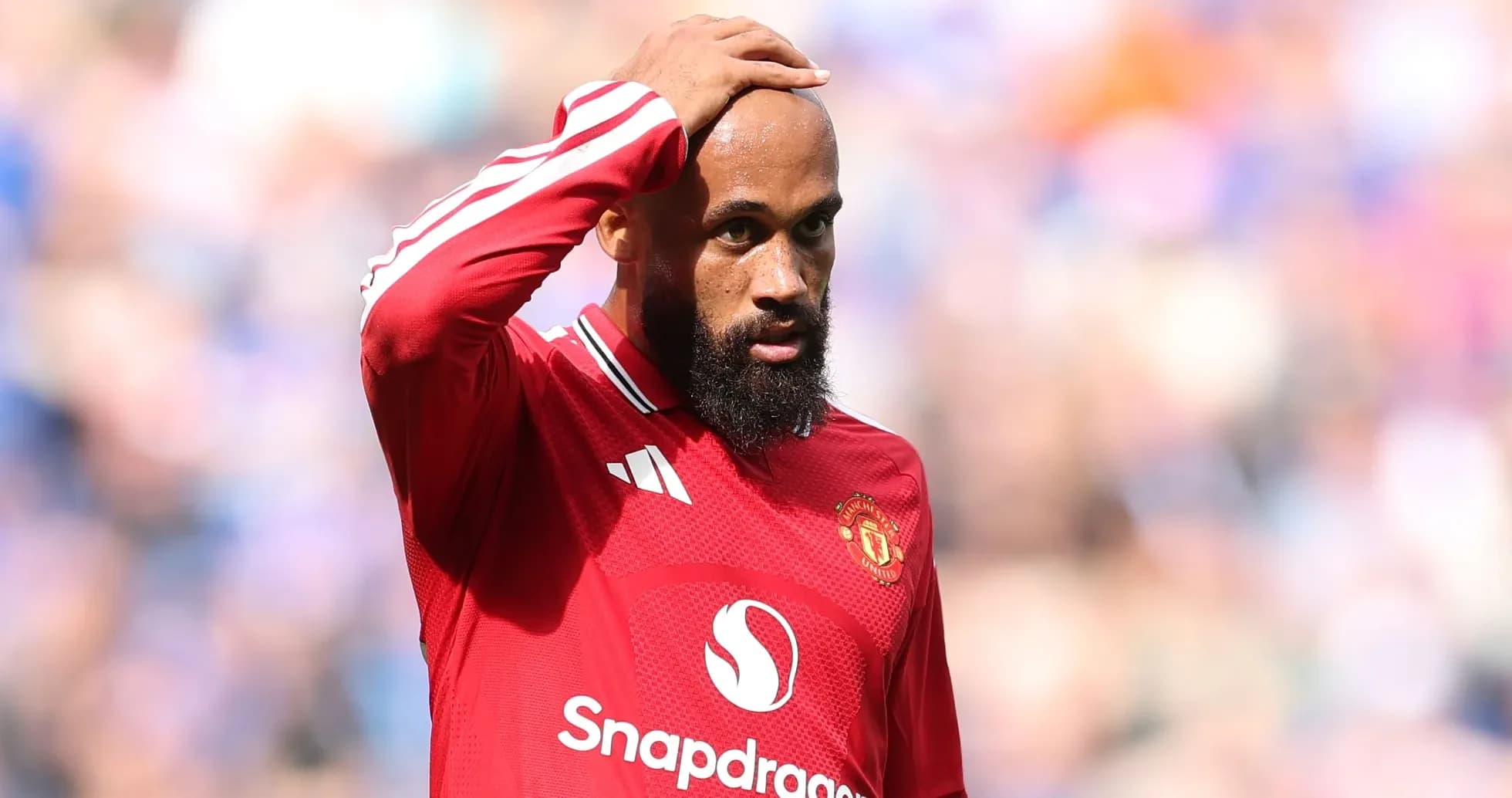 Jugador de Manchester United con camiseta roja en el campo