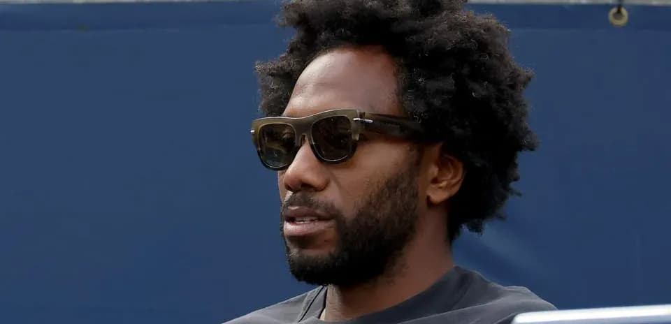 Hombre con gafas oscuras sentado en un evento