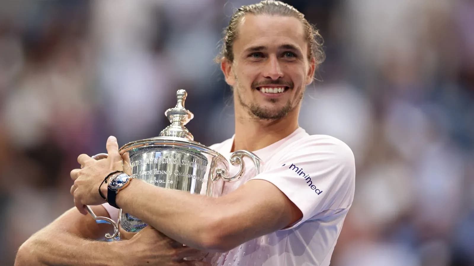 Jugador sosteniendo el trofeo del campeonato de tenis