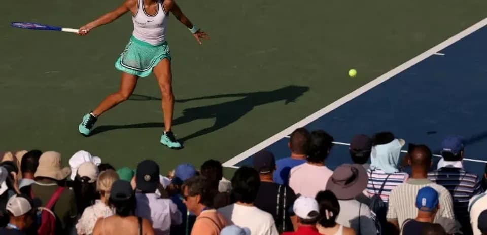 Jugadora de tenis golpeando la pelota en la cancha