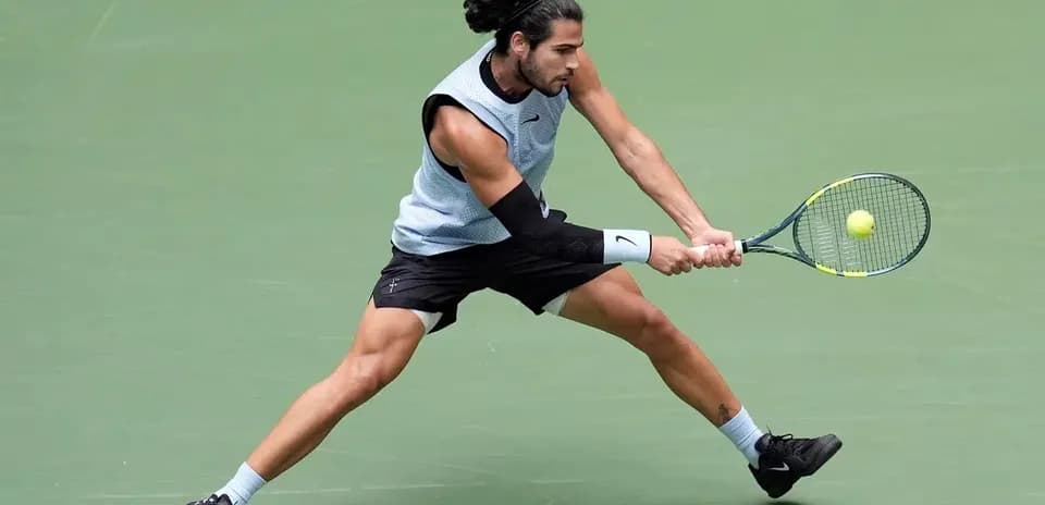 Jugador de tenis golpeando la pelota en la cancha