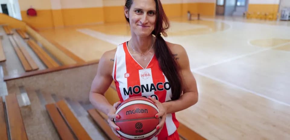 Jugadora de baloncesto con balón en gimnasio