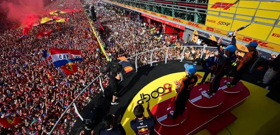 Podio con pilotos celebrando y multitud animando