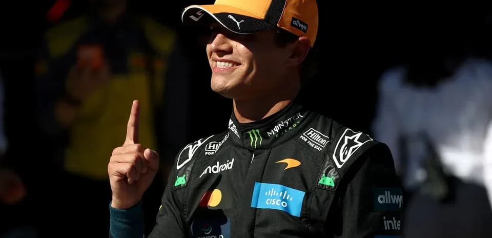 Piloto de McLaren señalando el número uno en el paddock