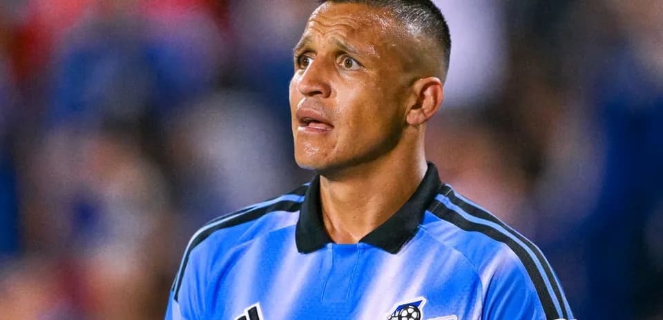 Jugador de fútbol con camiseta azul mirando hacia arriba