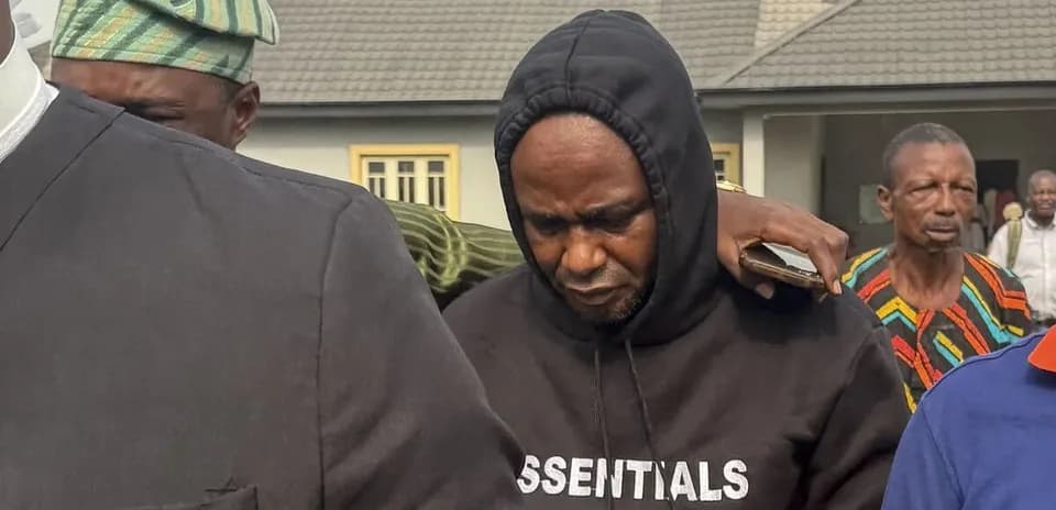 Hombre con sudadera oscuro siendo acompañado por otros