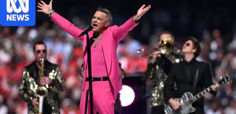Robbie Williams cantando en un evento musical
