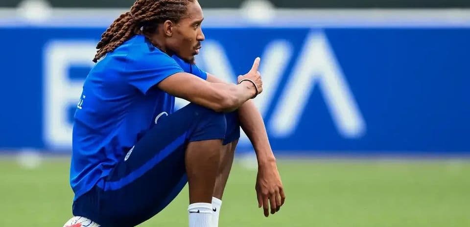 Jugador sentado con balón durante sesión de entrenamiento