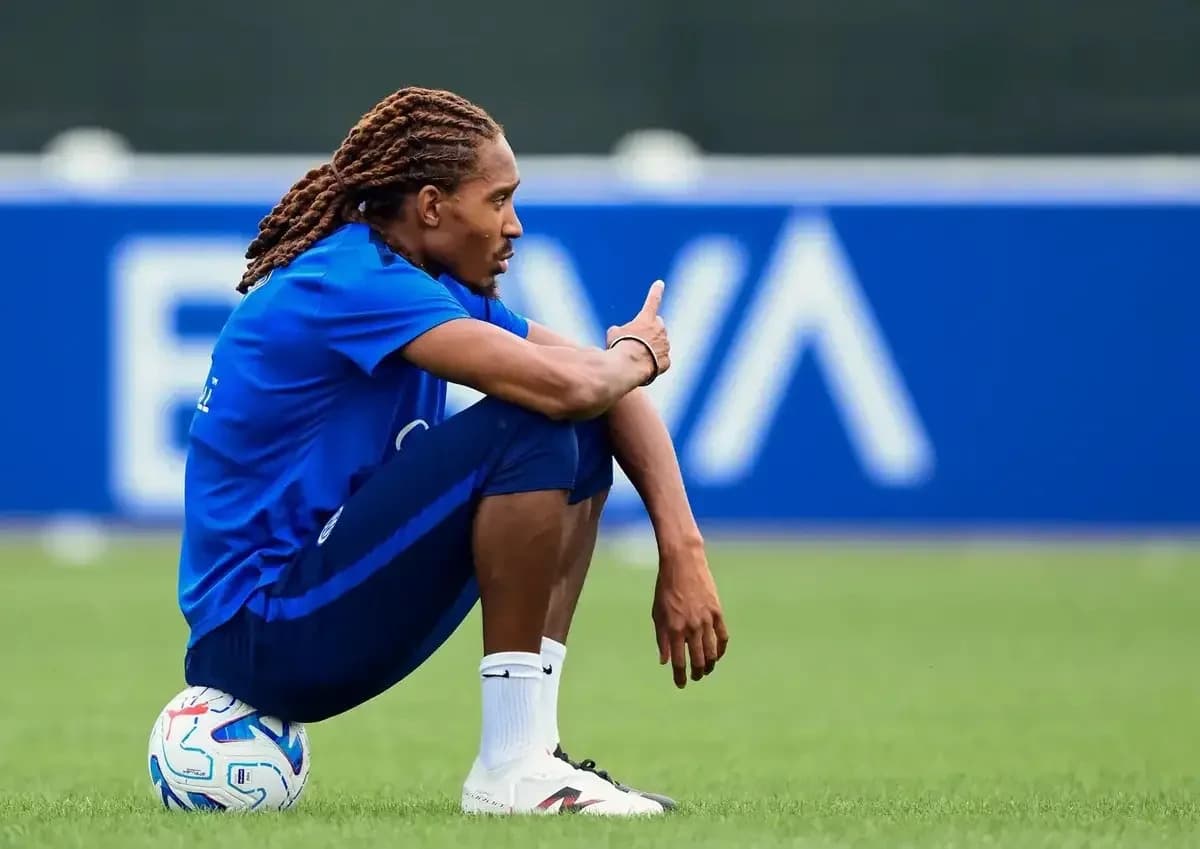 Jugador sentado con balón durante sesión de entrenamiento