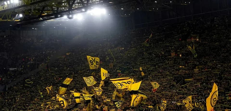 Aficionados de Borussia Dortmund agitando banderas en el estadio