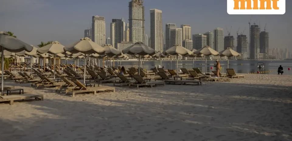 Playa con tumbonas y edificios modernos al fondo