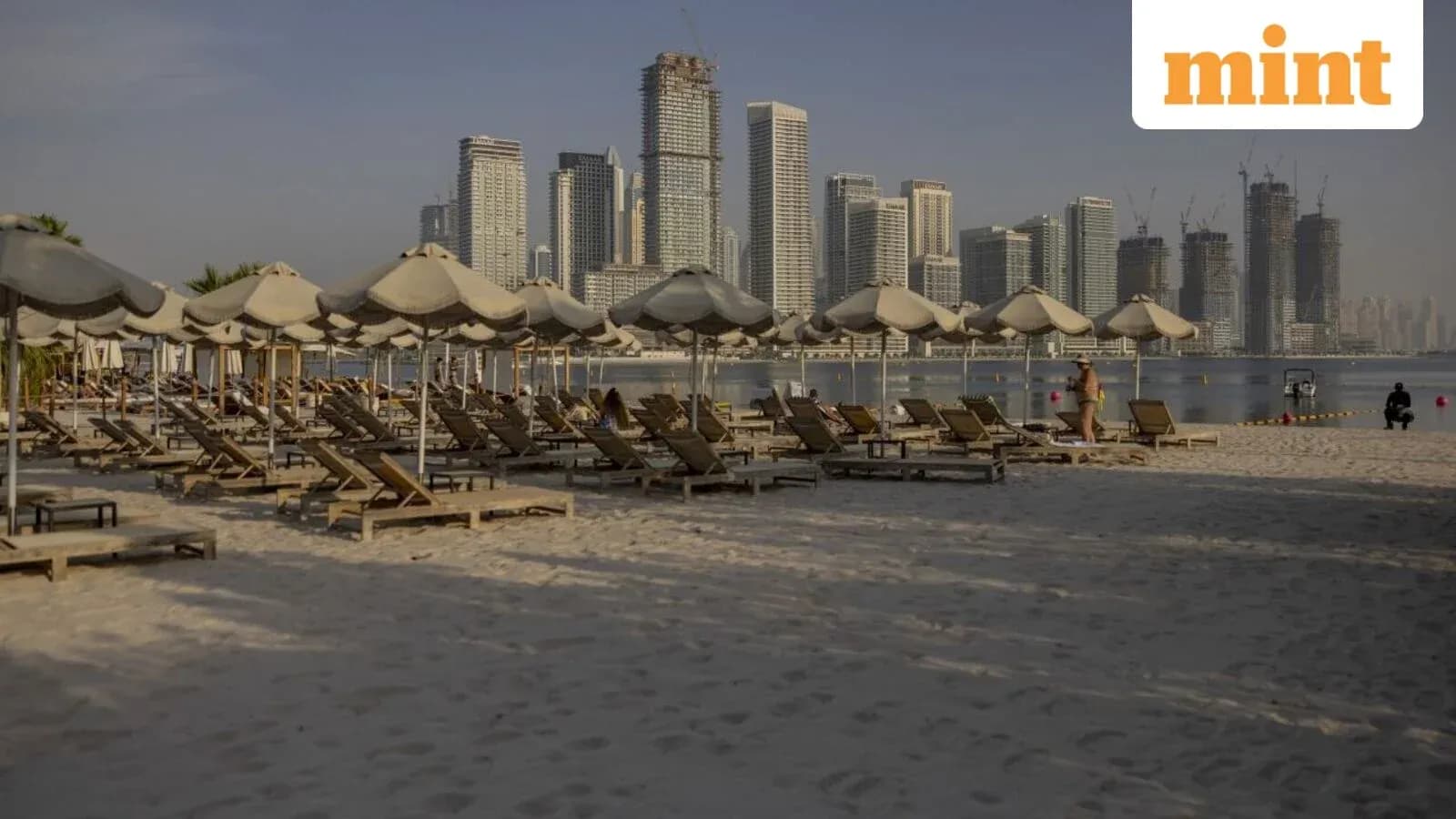 Playa con tumbonas y edificios modernos al fondo