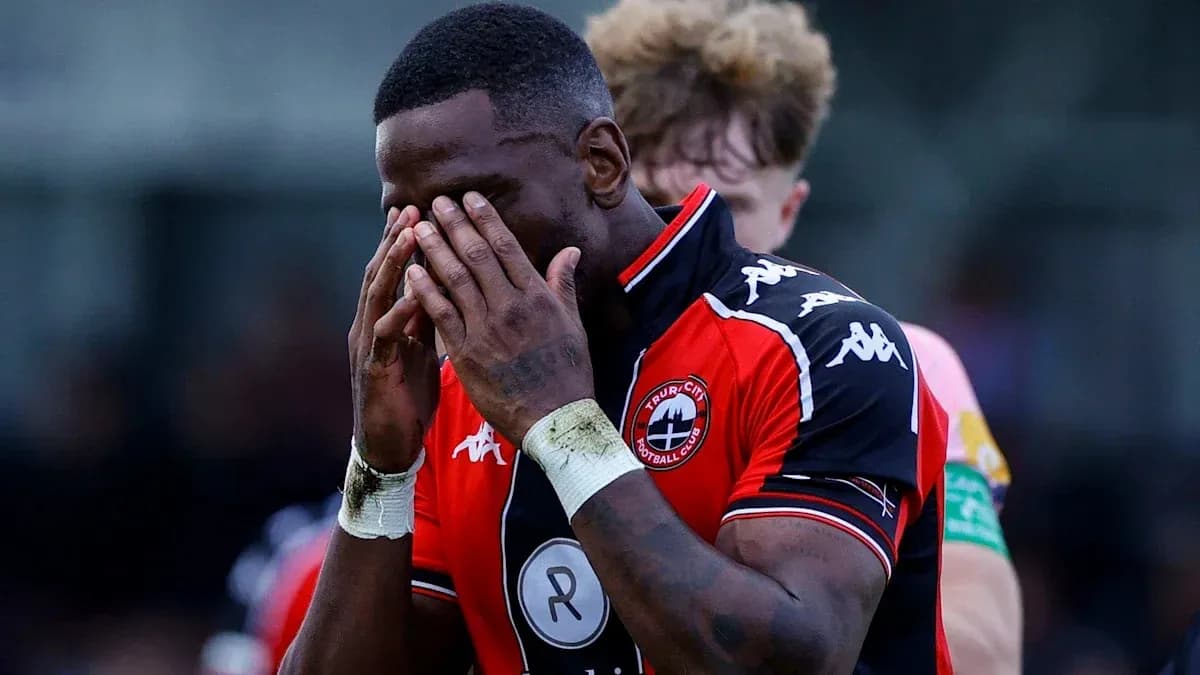 Jugador con camiseta de Truro City cubriendo su rostro