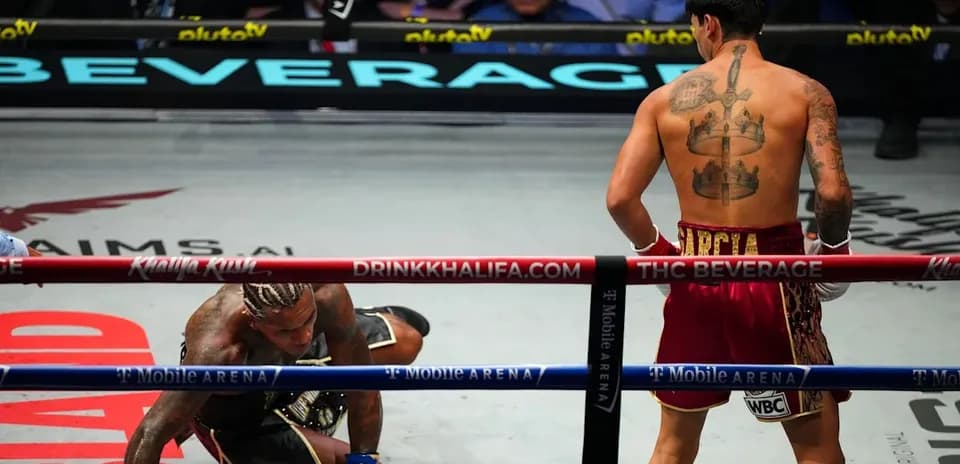 Boxeador en el suelo mientras otro observa