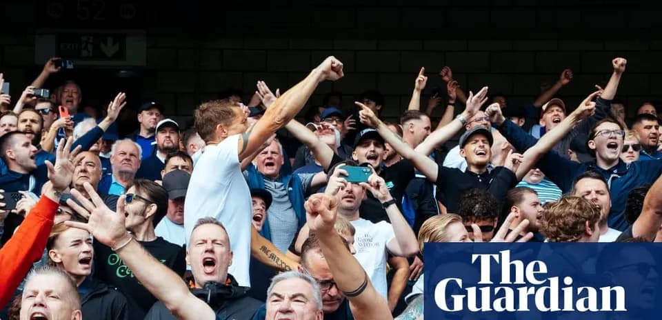 A crowd of fans cheering passionately at a match