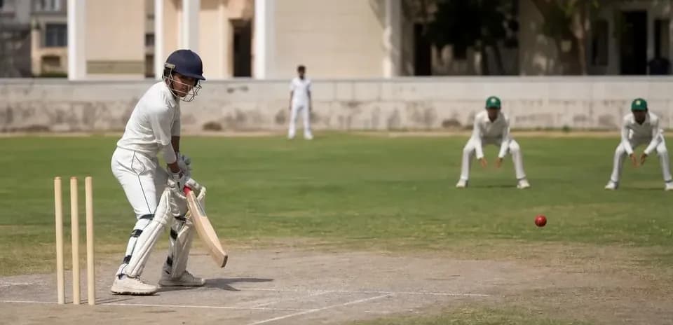 Jugador de cricket bateando mientras dos jugadores esperan