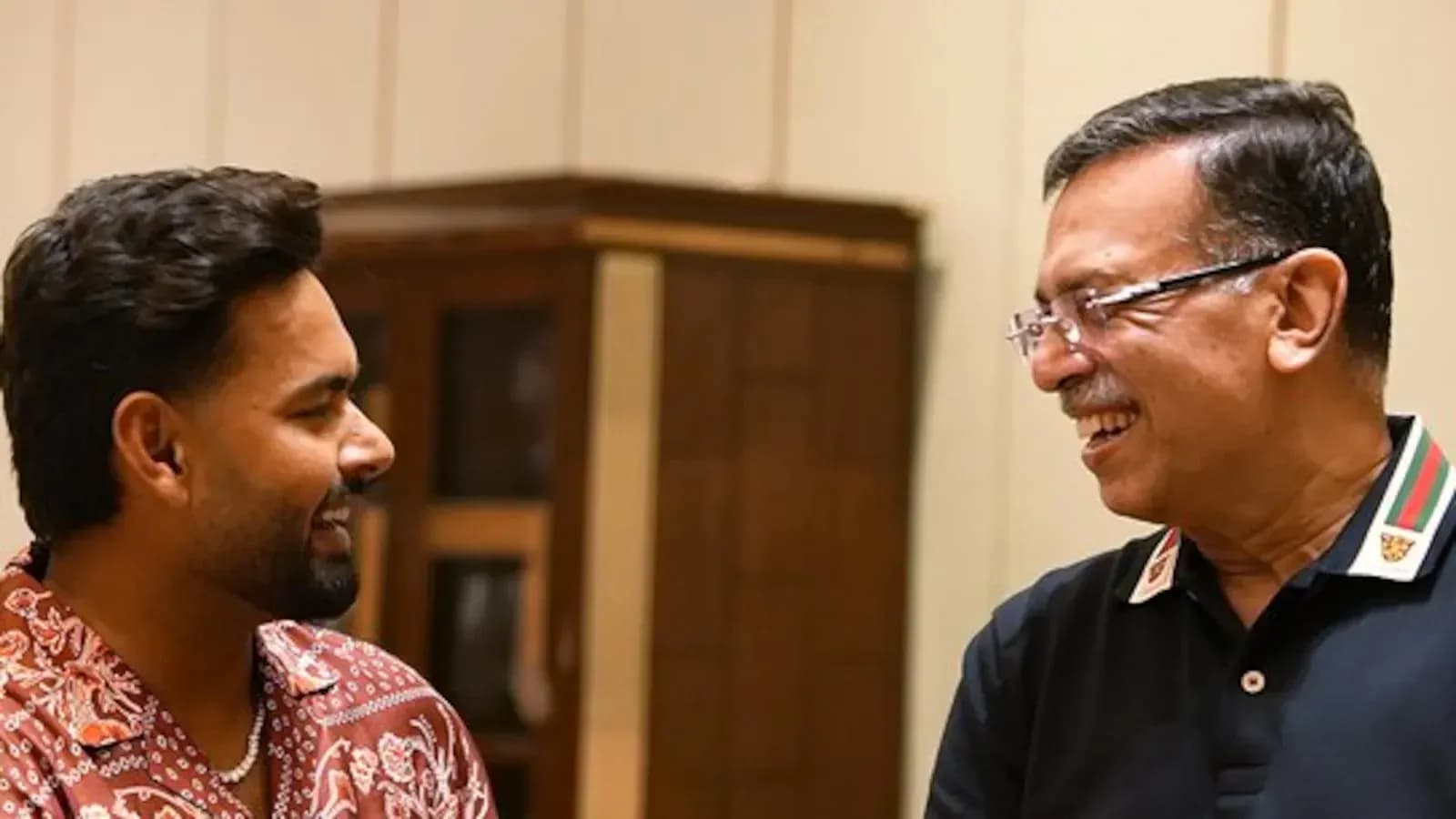 Dos hombres sonriendo y conversando en interior Dos hombres sonriendo y conversando en interior